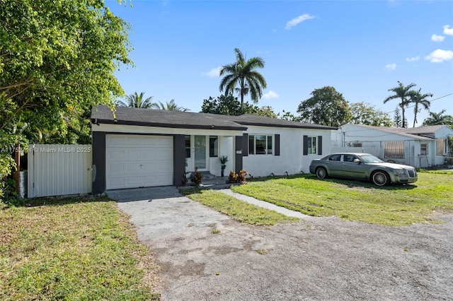 single story home with stucco siding, an attached garage, fence, driveway, and a front lawn