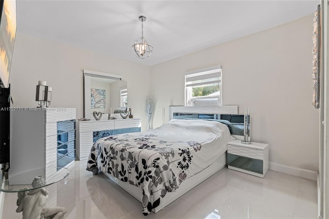 tiled bedroom featuring a notable chandelier and baseboards