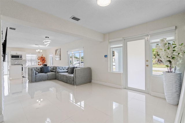 living room featuring a chandelier, tile patterned flooring, and visible vents