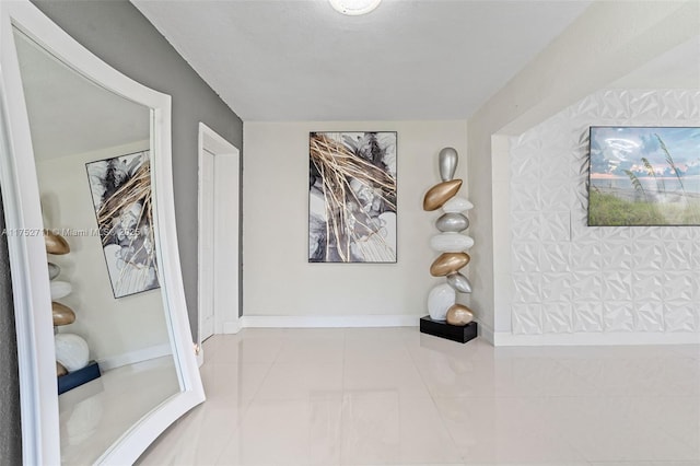 corridor featuring baseboards and tile patterned floors