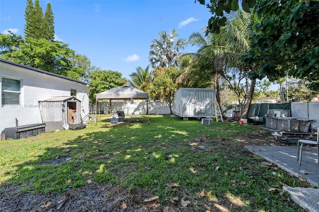 view of yard featuring a storage shed, fence, and an outdoor structure