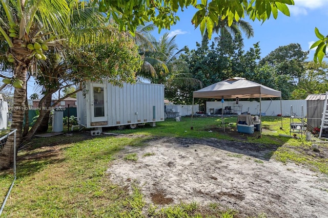 view of yard with a carport, an outbuilding, and a fenced backyard