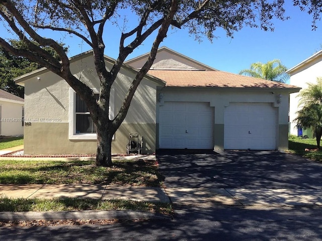 view of side of home with an attached garage, driveway, and stucco siding