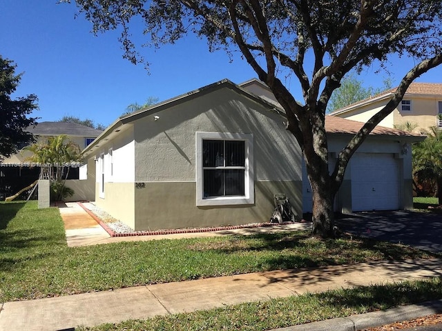 view of home's exterior with a garage, a yard, and stucco siding