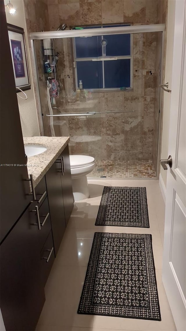 full bath with tile patterned floors, a shower stall, toilet, and vanity