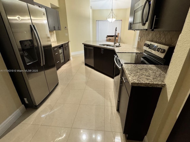 162 NW 207th Ave, Pembroke Pines, FL 33029 - kitchen featuring stainless steel appliances, backsplash, baseboards, dark cabinetry, and a peninsula