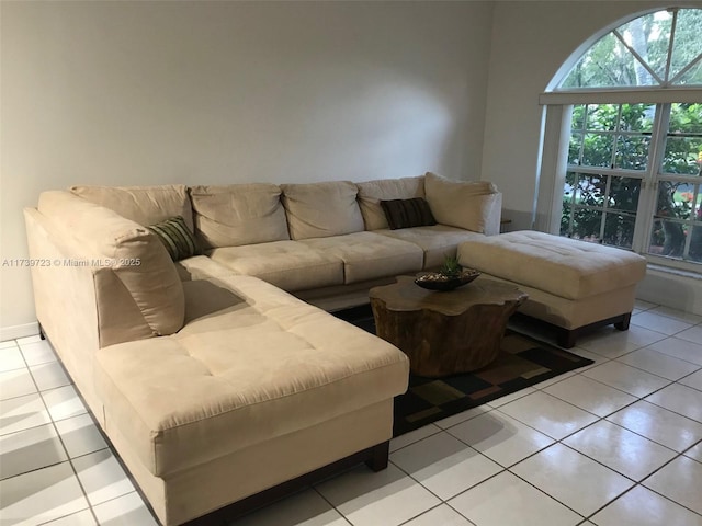 living area with baseboards and light tile patterned floors