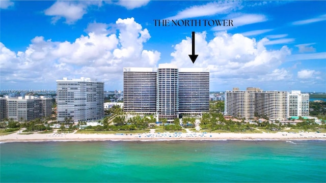 birds eye view of property with a water view, a view of city, and a beach view