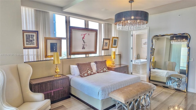 bedroom with light wood-type flooring and an inviting chandelier