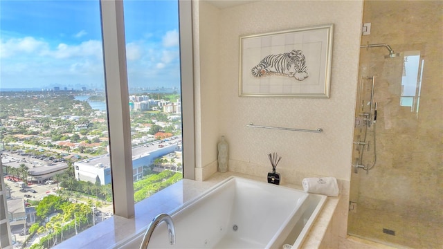 full bath with a stall shower, a city view, and a jetted tub