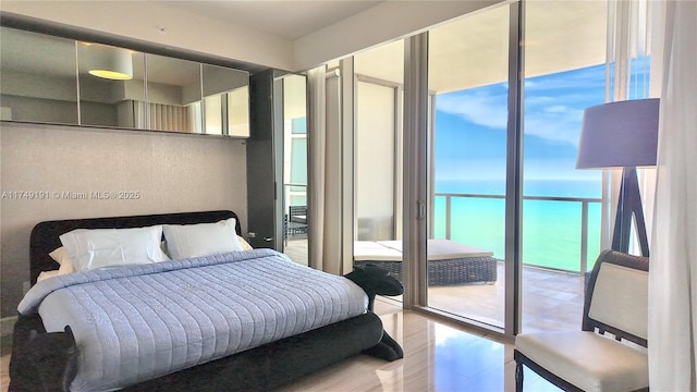 bedroom featuring a water view and expansive windows