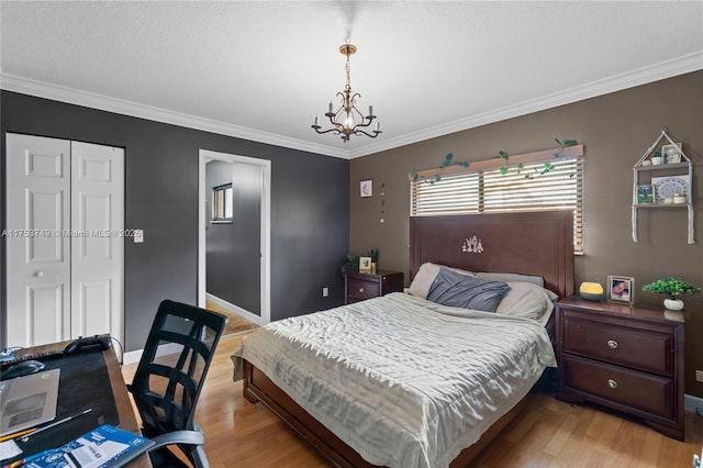 bedroom with light wood-type flooring, an inviting chandelier, ornamental molding, and a closet