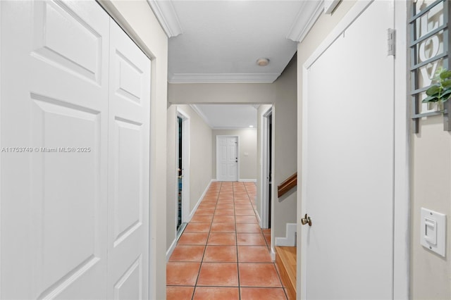 hallway featuring light tile patterned floors, baseboards, and crown molding