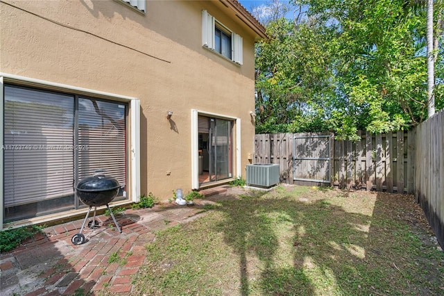 view of yard featuring a fenced backyard, a patio, and central AC unit