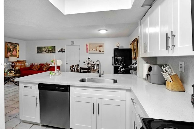 kitchen featuring a peninsula, light countertops, black fridge, stainless steel dishwasher, and a sink