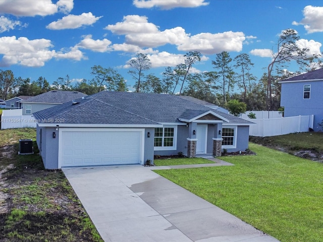 ranch-style home featuring a shingled roof, concrete driveway, an attached garage, fence, and a front yard