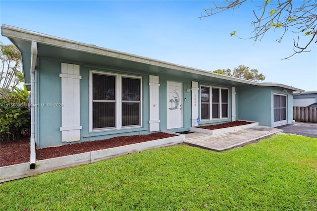 exterior space with stucco siding, covered porch, and a front yard