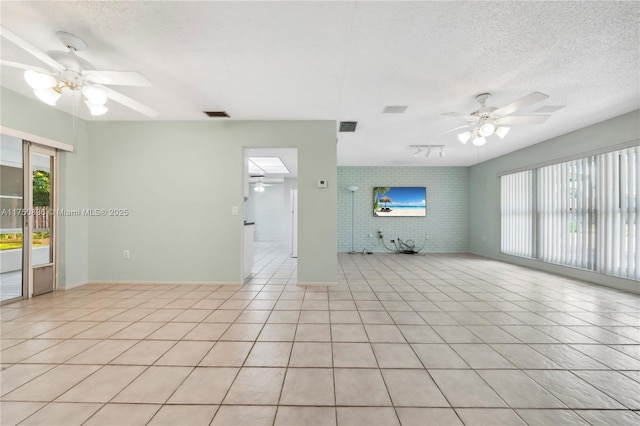 unfurnished room with light tile patterned floors, plenty of natural light, visible vents, and a ceiling fan