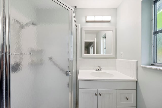 bathroom featuring a shower stall, decorative backsplash, and vanity