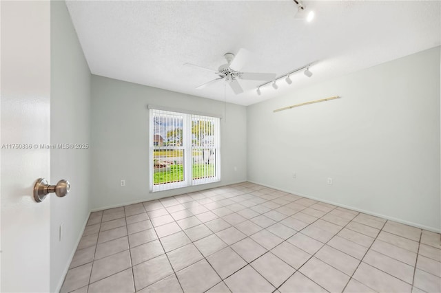 unfurnished room with a textured ceiling, rail lighting, and a ceiling fan