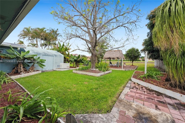 view of yard featuring an outbuilding, fence, and a gazebo