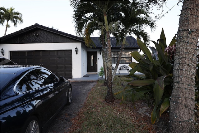 ranch-style home featuring a garage and stucco siding