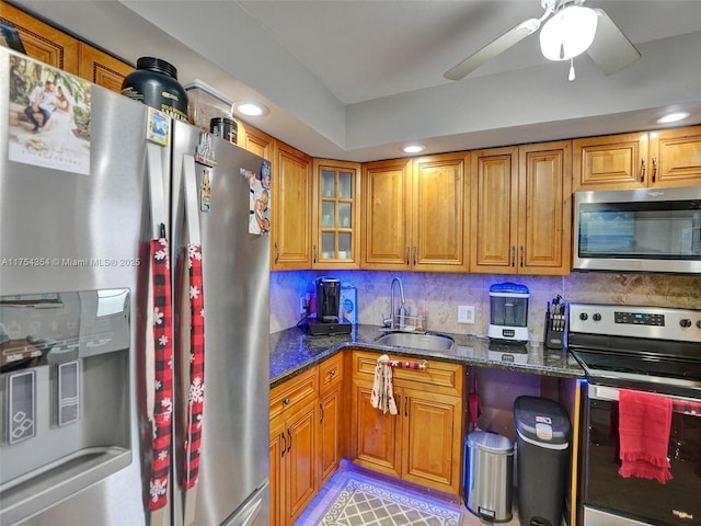 kitchen featuring appliances with stainless steel finishes, brown cabinets, and a sink