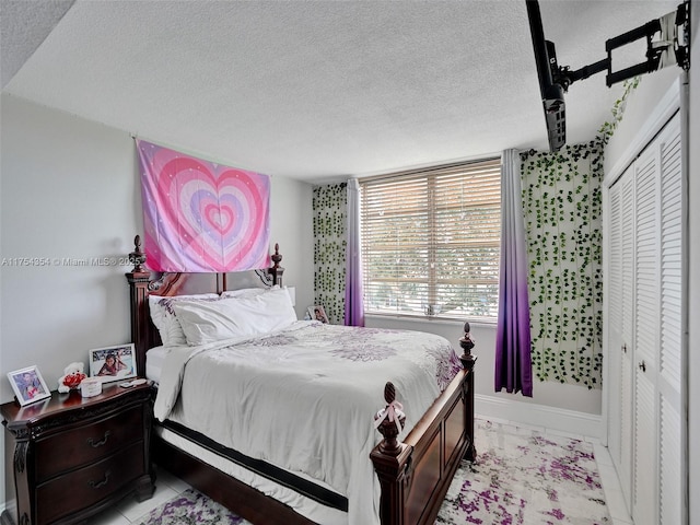 bedroom with a textured ceiling and baseboards