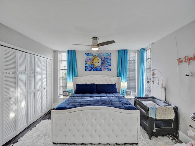 bedroom with baseboards, a ceiling fan, a closet, and wood finished floors