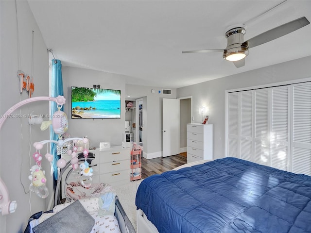 bedroom featuring a closet, visible vents, a ceiling fan, and wood finished floors