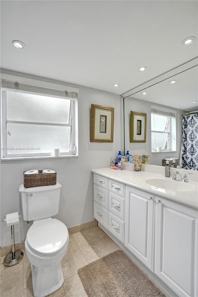 bathroom with recessed lighting, plenty of natural light, vanity, and toilet