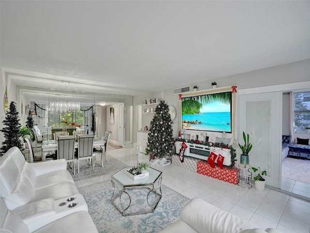 tiled living area with a chandelier and visible vents