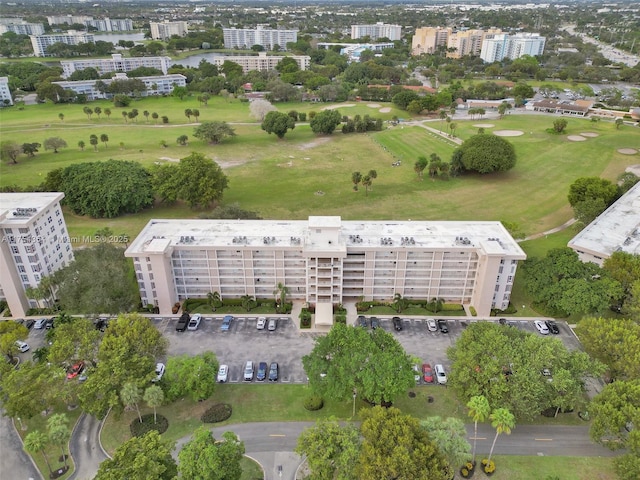 birds eye view of property featuring view of golf course and a city view