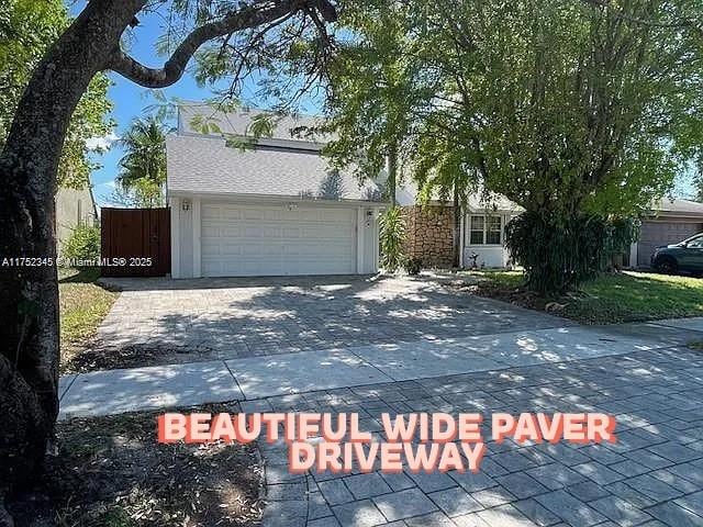 1350 S Fieldlark Ln, Homestead, FL 33035 - obstructed view of property with driveway and an attached garage