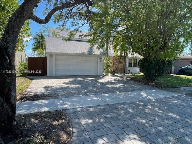1350 S Fieldlark Ln, Homestead, FL 33035 - obstructed view of property with decorative driveway and an attached garage