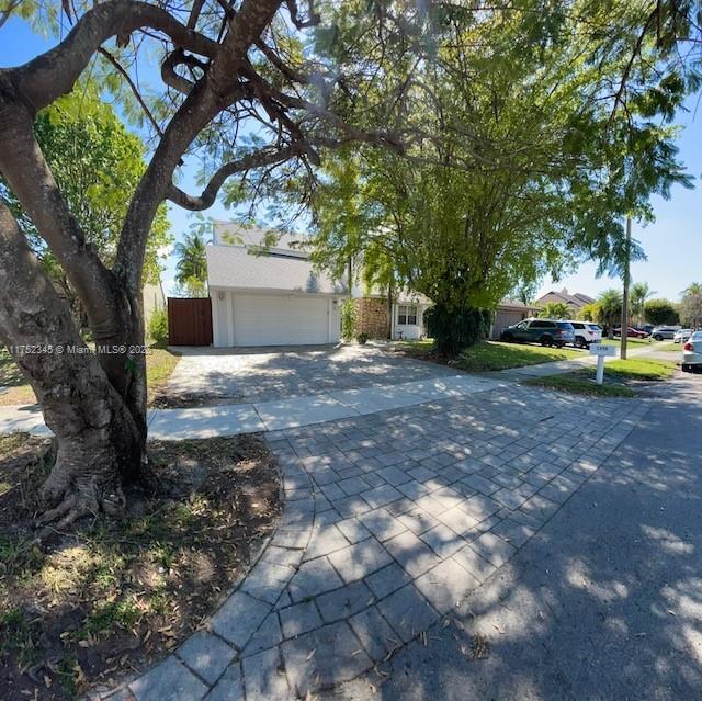 1350 S Fieldlark Ln, Homestead, FL 33035 - view of property hidden behind natural elements featuring driveway and a garage