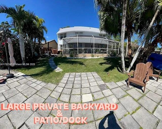1350 S Fieldlark Ln, Homestead, FL 33035 - rear view of house with a lawn, a patio area, and glass enclosure
