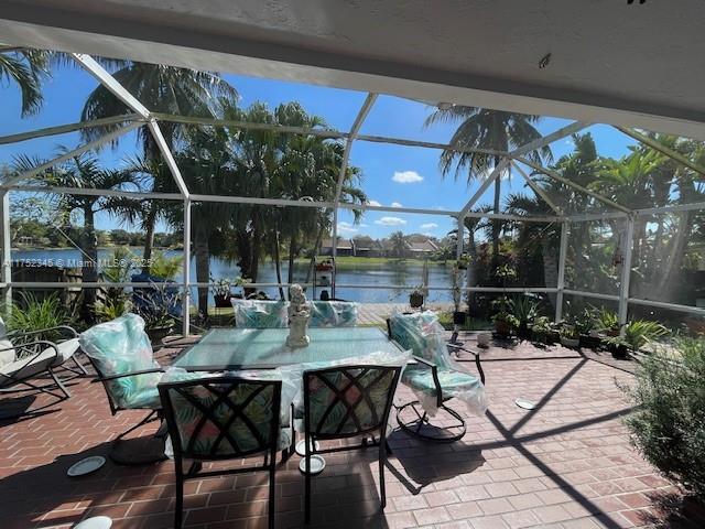 1350 S Fieldlark Ln, Homestead, FL 33035 - view of patio / terrace with glass enclosure and a water view