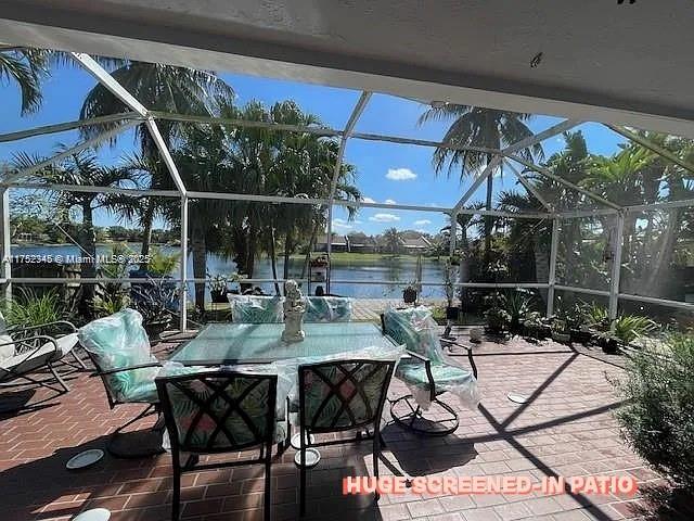 1350 S Fieldlark Ln, Homestead, FL 33035 - view of patio / terrace with glass enclosure and a water view