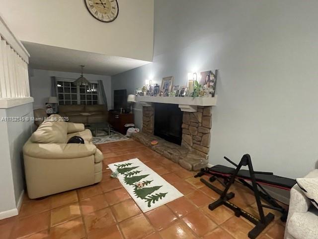 1350 S Fieldlark Ln, Homestead, FL 33035 - living room featuring tile patterned floors, a fireplace, and a towering ceiling