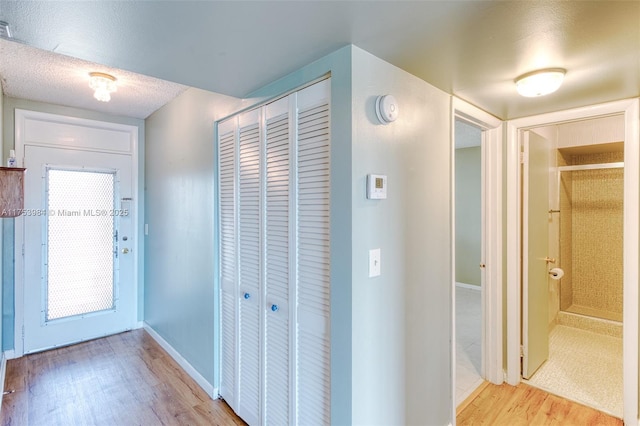 interior space featuring a textured ceiling, baseboards, and wood finished floors