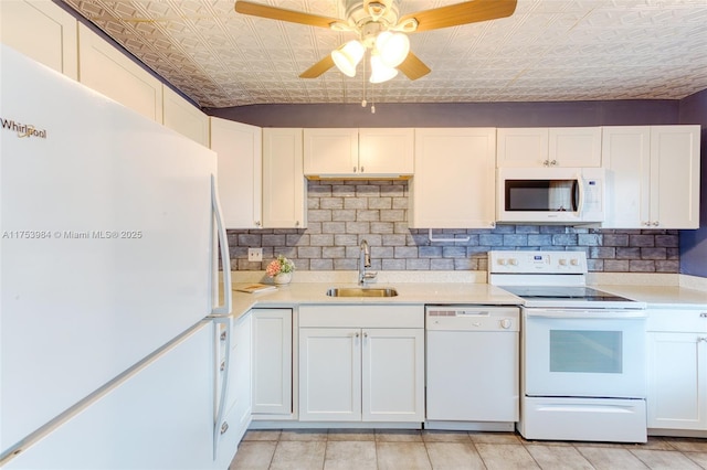 kitchen featuring an ornate ceiling, white appliances, light countertops, and a sink