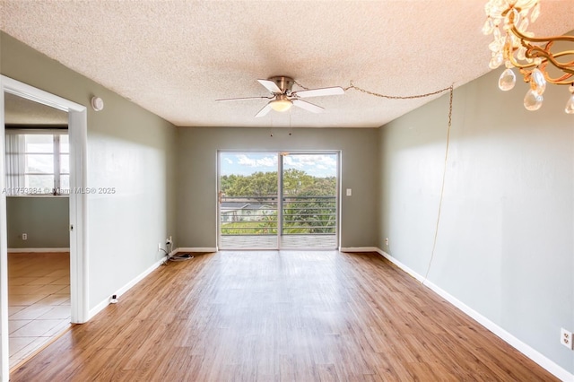 spare room featuring a ceiling fan, a textured ceiling, baseboards, and wood finished floors