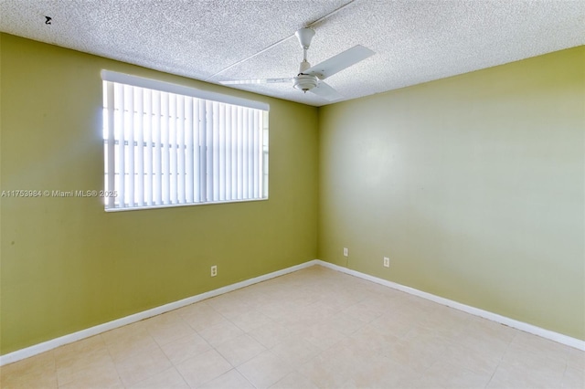 unfurnished room with ceiling fan, a textured ceiling, and baseboards