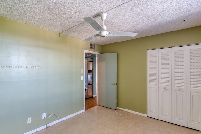 unfurnished bedroom with a textured ceiling, baseboards, and a closet