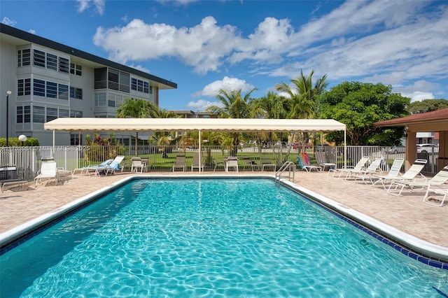 community pool with a patio and fence