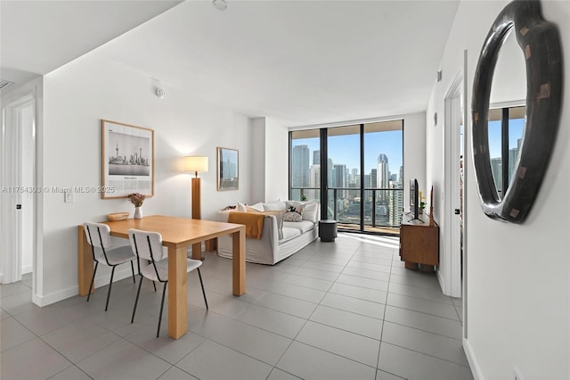 dining space featuring tile patterned flooring, expansive windows, and baseboards