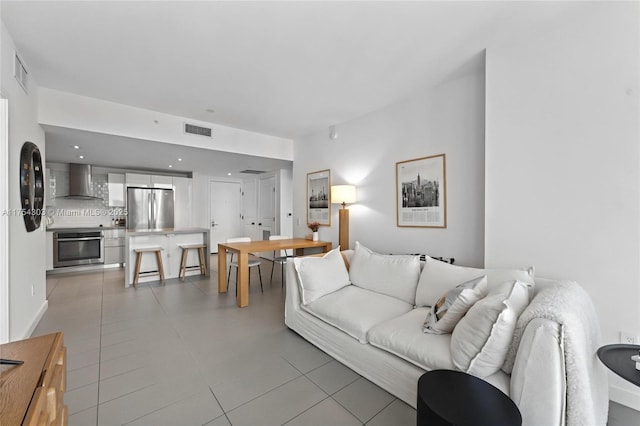 living room featuring light tile patterned floors and visible vents