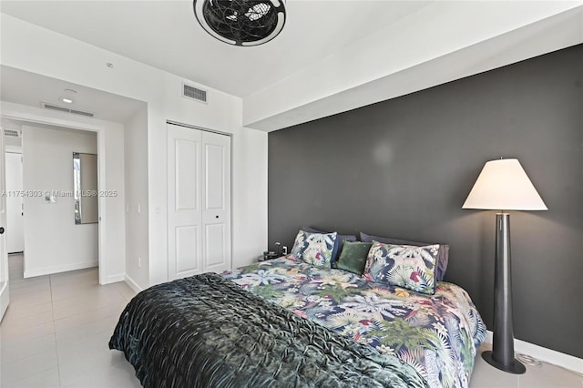 bedroom featuring a closet, visible vents, baseboards, and tile patterned floors