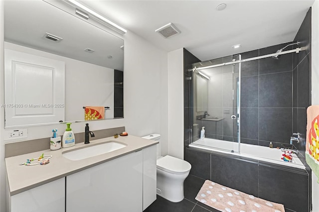 full bathroom featuring toilet, tiled shower / bath, visible vents, and vanity